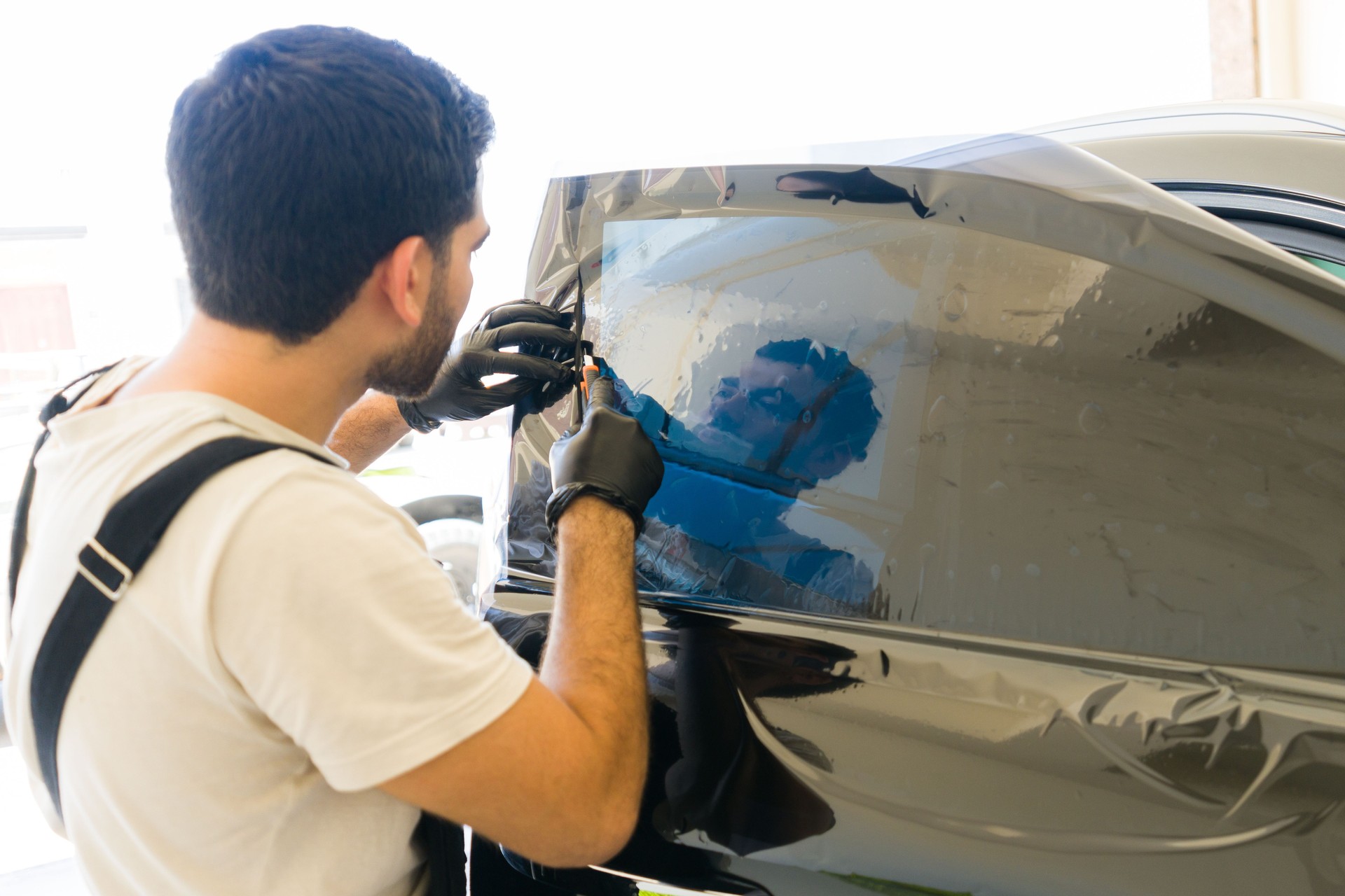 Specialist installing tinting film on car window